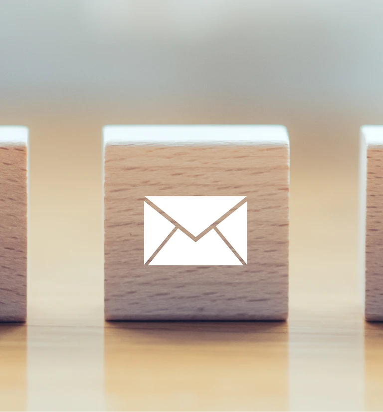 Wooden block with a white envelope icon symbolizing email or communication.